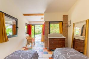 a bedroom with two beds and a dresser and a mirror at Mas Le Bragalou in Courry +24 photos