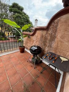 a grill sitting on a patio next to a wall at Cozy Loft & Terrace in Antigua in Antigua Guatemala