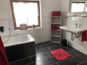 a bathroom with a white tub and a sink at Haus Peschl Fewo 2 in Neureichenau +7 photos