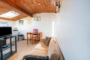 a living room with a couch and a television at Joli T3 Pays Basque Tarnos Landes in Tarnos