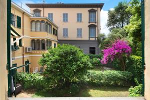 a building with a pink flowering tree in front of it at Oceane Paradise- Charlot in Levanto
