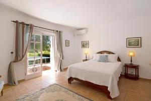 une chambre blanche avec un lit et une fenêtre dans l'établissement Casa Alcantarilha, à Pêra 20 autres photos