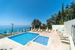 a swimming pool with chairs and a view of the ocean at Mazis Studio B2 in Agios Gordios