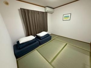 a room with two blue chairs and a window at PHEBE3osaka in Osaka