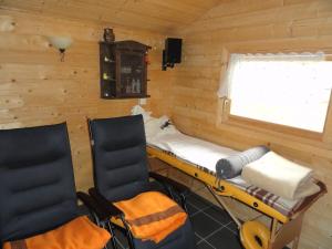 two chairs and a bed in a room with wooden walls at Ferienwohnung Wutachtal in Höfe