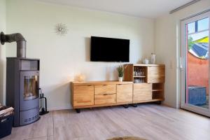 a living room with a tv on a wall at Haus Segelboot Hirtenweg 3c in Zingst