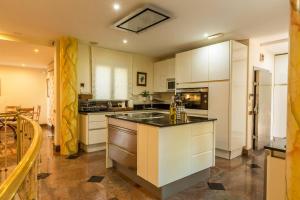 une cuisine avec des placards blancs et un grand îlot dans l'établissement Villa Albella, à San Agustín