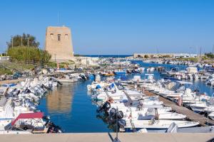 un grupo de barcos atracados en un puerto con una torre en Casa tra cielo e mare in Salento, en San Foca