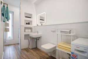 a white bathroom with a toilet and a sink at Wohnung Abendrot in Heringsdorf +15 photos