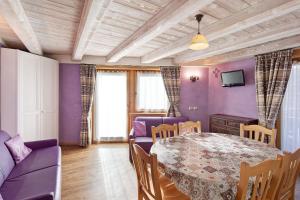 a dining room with a table and purple walls at Chalet Picchio Quadrilocale in Livigno