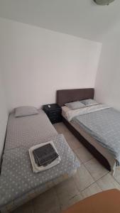 Dos camas una al lado de la otra en una habitación. en Simpi, en Pržno