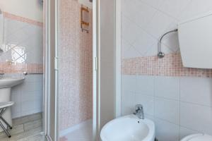 a bathroom with a shower and a toilet and a sink at Casa Claudia a Porto Azzurro in Porto Azzurro +12 photos
