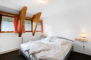QuitzdorfにあるFerienwohnung - Finnhütteのベッドと2つの窓がある寝室