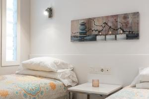 een slaapkamer met een bed en een tafel en een schilderij bij Stunning marina view apartment in Fuengirola