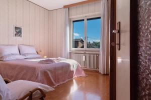 a bedroom with two beds and a window at Casa Rosanna al lago in Maccagno Inferiore