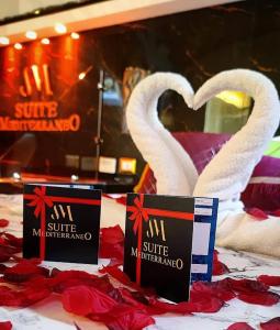 two white swans sitting on top of a bed at Suite Mediterraneo in Civitavecchia