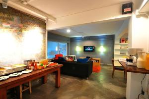 a living room with a couch and a tv at Qilombo Hostel Silom in Bangkok