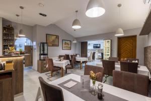 ein Restaurant mit Tischen und Stühlen und einer Küche in der Unterkunft Hotel Gurman in Horšovský Týn