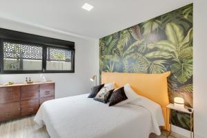 a bedroom with a bed and a tropical wallpaper at Heaven Ocin vacacional in Telde +22 photos