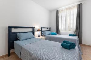 a bedroom with two beds with blue pillows at Las Catalinas in Gran Tarajal +33 photos