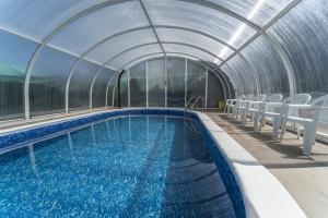 an indoor swimming pool with chairs in a building at Valle De Juarros in San Adrián de Juarros