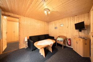 ReichendorfにあるBungalow 37b - Kimbuchtのリビングルーム(黒いソファ、テレビ付)