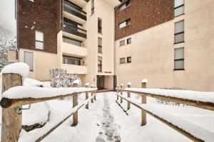 una recinzione coperta di neve di fronte a un edificio di Studio Herboully a Corrençon-en-Vercors