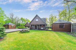 a large yard with a house and a picnic table at La Fortuna Lodges in Stirling