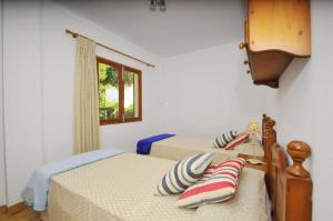 a bedroom with two beds and a window at Cora in Port d'Alcudia