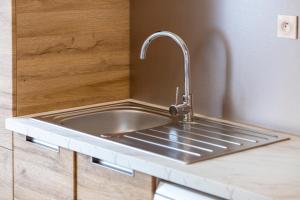 贝诺代T2 avec jardin 1,2km de la plage的厨房水槽，台面上有水龙头