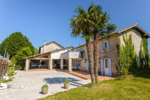 a house with a palm tree in front of it at Chambre d'hote Rubis in Genouillé