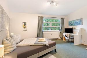 Neu FahrlandにあるAlbrechtshof Apartment 3のベッドと机と窓のある寝室