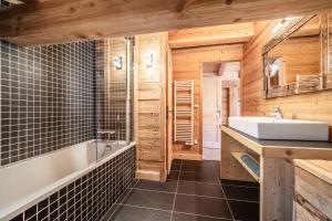 a bathroom with a tub and a sink in a room at Chalet L'aube claire - 5 étoiles in Morzine +28 photos