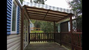 eine Pergola über einem Deck auf einem Haus in der Unterkunft Bungalow Camping 4 à 8 personnes in Les Mathes