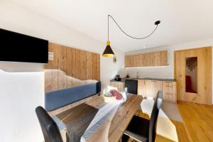 a kitchen and dining room with a wooden table and chairs at Töniglerhof Apt Abendrot in Trodena