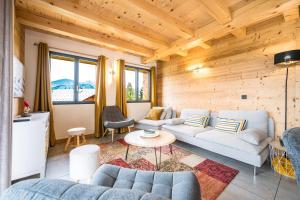 a living room with couches and a table at Chalet les 2 Soeurs in Cohennoz
