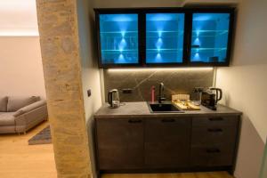 a kitchen with a sink and blue lights above it at Gh Alte Post - Top2 Super 6 in Gmünd in Kärnten