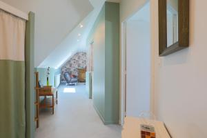 un couloir d'une maison aux murs verts dans l'établissement Gîte Kerli cosy 2kms plage, à Trévou-Tréguignec