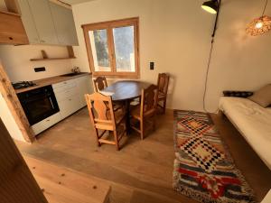 a kitchen with a table and chairs in a room at Au Soleil in Séez