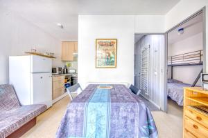 a small room with a table and a kitchen at Chalet dans résidence piétonne in Hourtin +14 photos