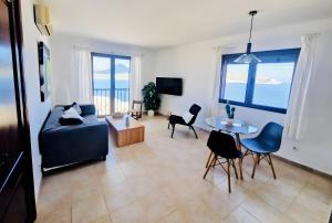 a living room with a couch and a table and chairs at Tramuntana in Cala Ratjada