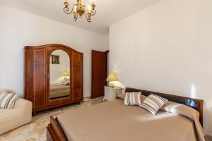 マリーナ・ディ・カッラーラにあるCasa Chanel a Marina di Carraraのベッドルーム1室(ベッド1台、鏡、ソファ付)