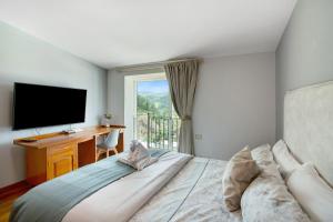 a bedroom with a bed with a desk and a television at Carmelo y Carmela 4 in Teror