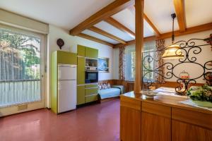 une cuisine avec des armoires vertes et un réfrigérateur blanc dans l'établissement Villa Coris Ferienwohnung Palma, à Merano 20 autres photos