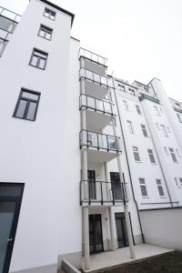 a white building with balconies on the side of it at Céleste Suites in Vienna