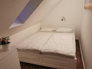 Cama blanca en habitación con techo púrpura en Kapitänsferienhaus Romantik, en Schaprode 2 fotos más