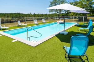 a swimming pool with chairs and an umbrella at Océan Ouest - Domaine Des Landes in Lesperon +14 photos