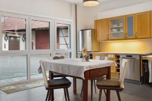 una cocina con mesa y sillas y una cocina con ventanas en Maiglöckchen, en Unterwittighausen 19 fotos más