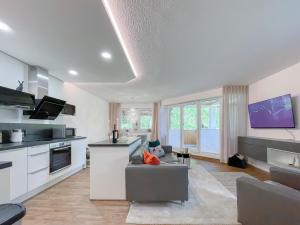 a living room with a couch and a kitchen at Schwarzwald Top Apartment in Lenzkirch