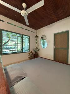 a bedroom with a bed and a ceiling fan at Backpackers in Matara